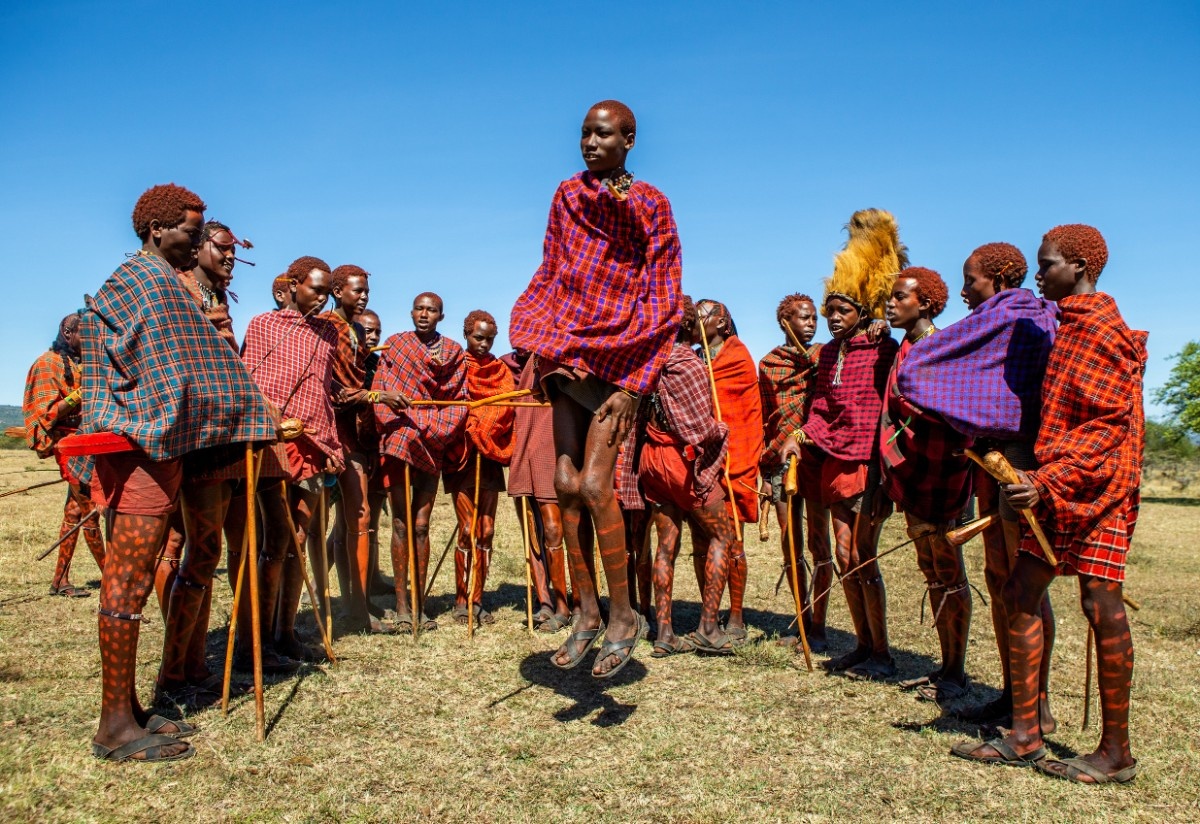 Maasai people in traditional dress welcoming visitors to their village — 2400×1400